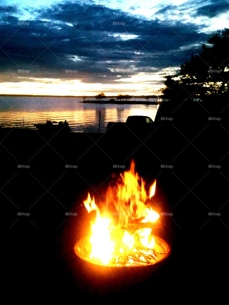 Beautiful Sunset over the lake, behind a toasty campfire. Camping at Lake Corpus Christi in South Texas.