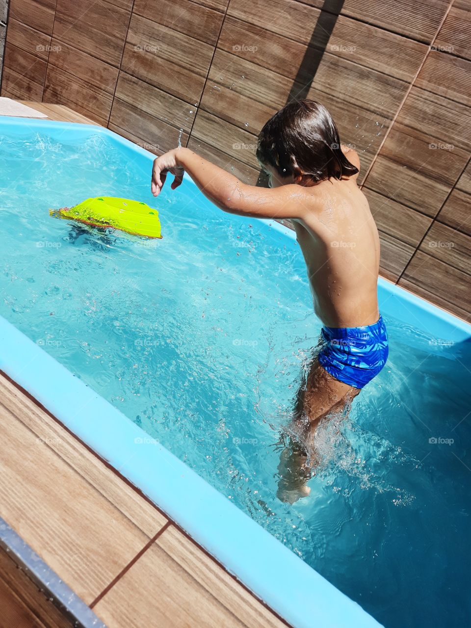 child jumping in the pool cooling off