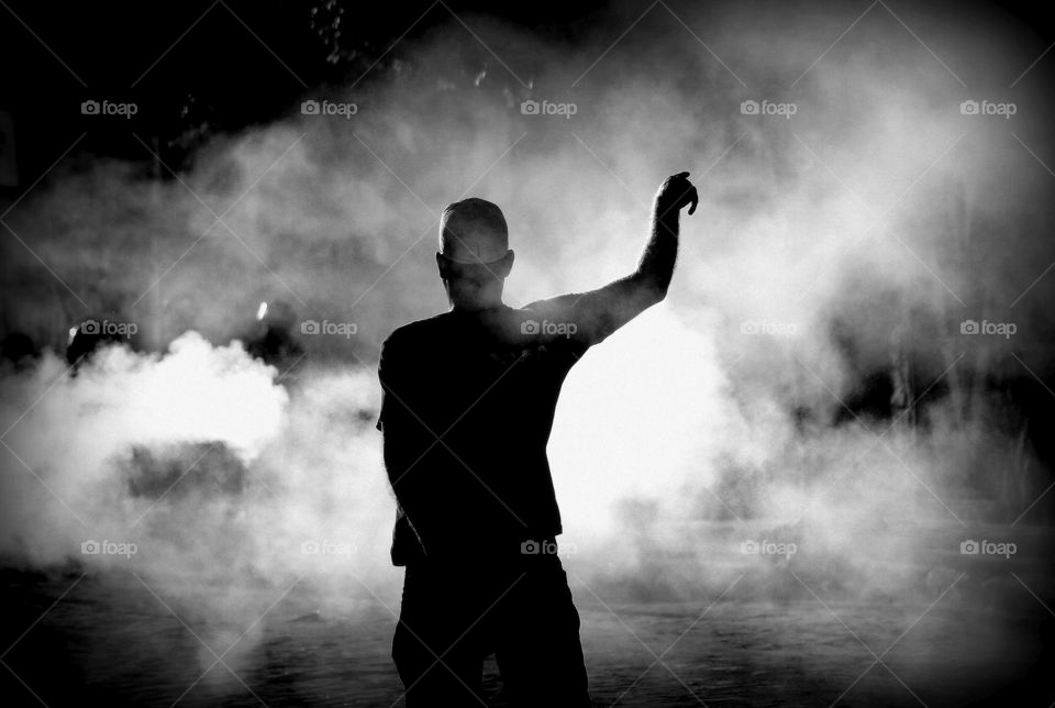 silhouette of a man on smoke-filled street