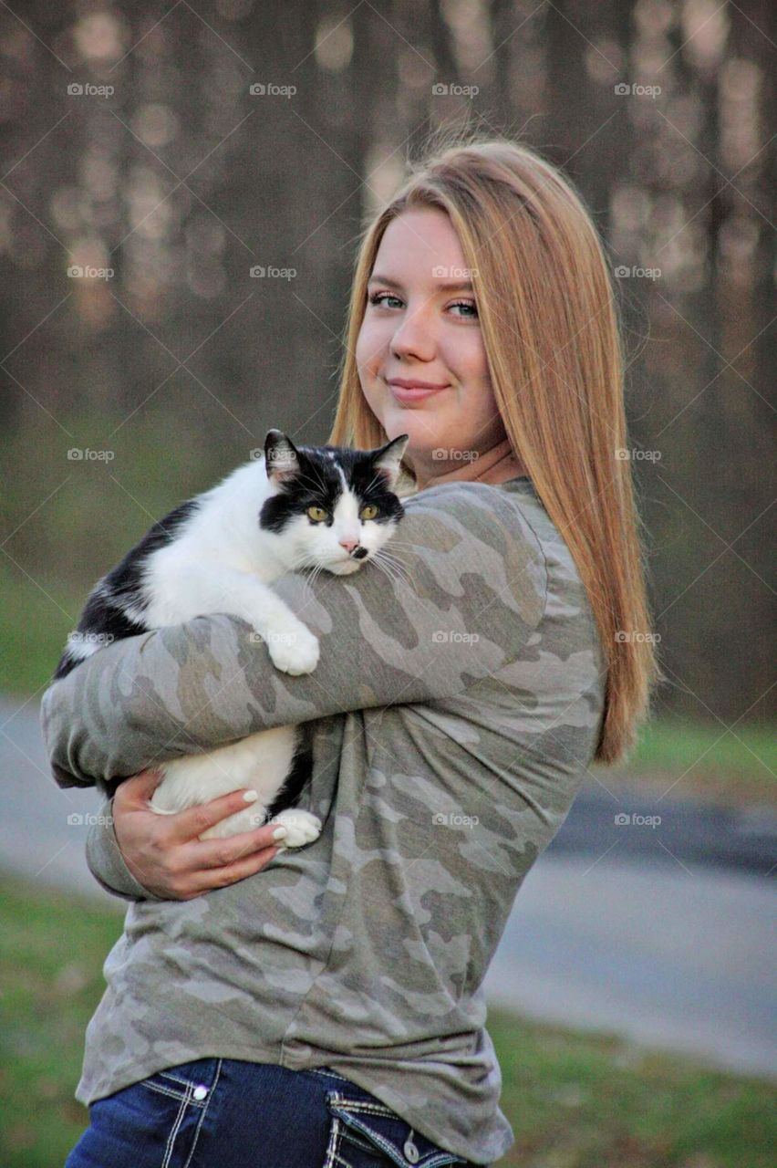 Girl hold a black and white cat