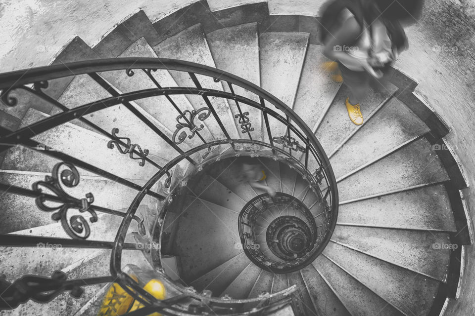 Spiral staircase in black and white with yellow shoes