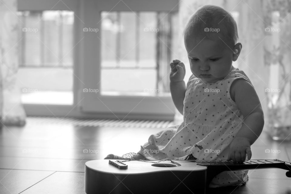 Baby girl touching guitar string