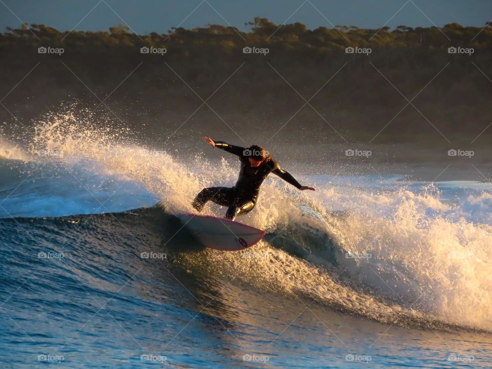 Girl surfing at sunset