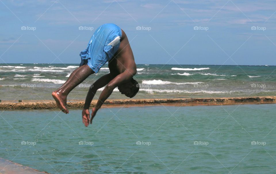 Young Boy Jumping Into Salt Water Pool