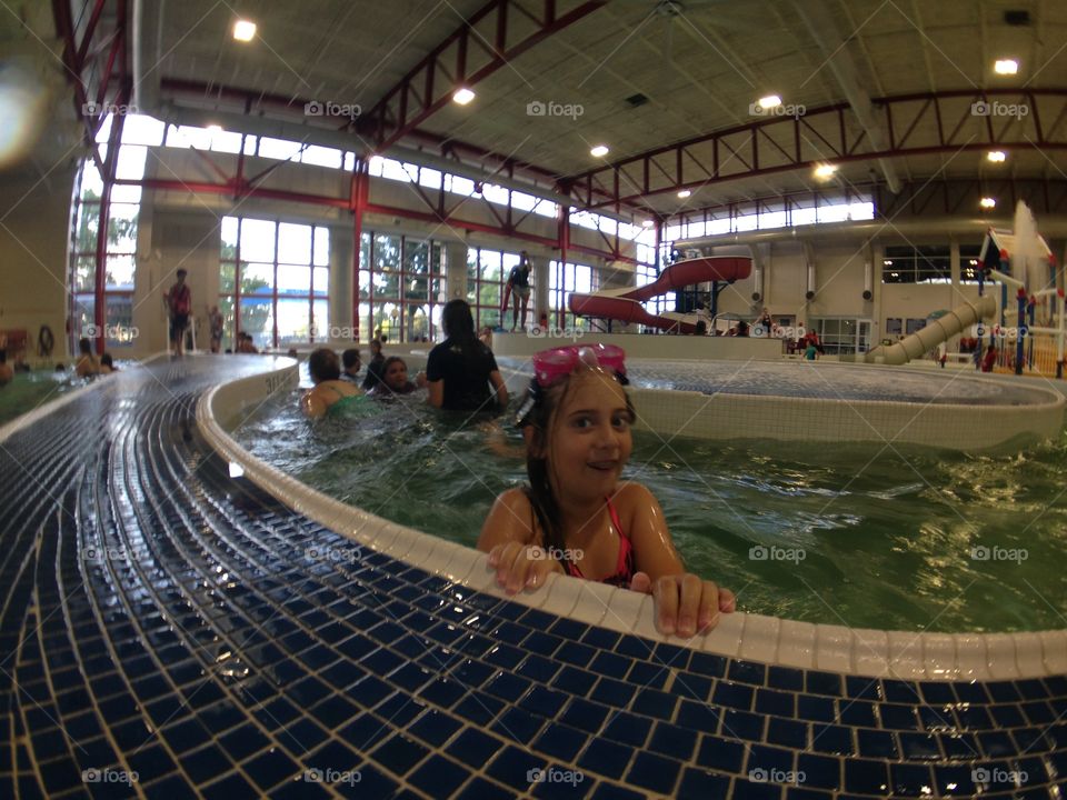 Round and round she goes. Girl in the lazy river at an indoor water park