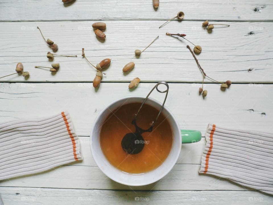 Cup of tea and white sleeves of sweater