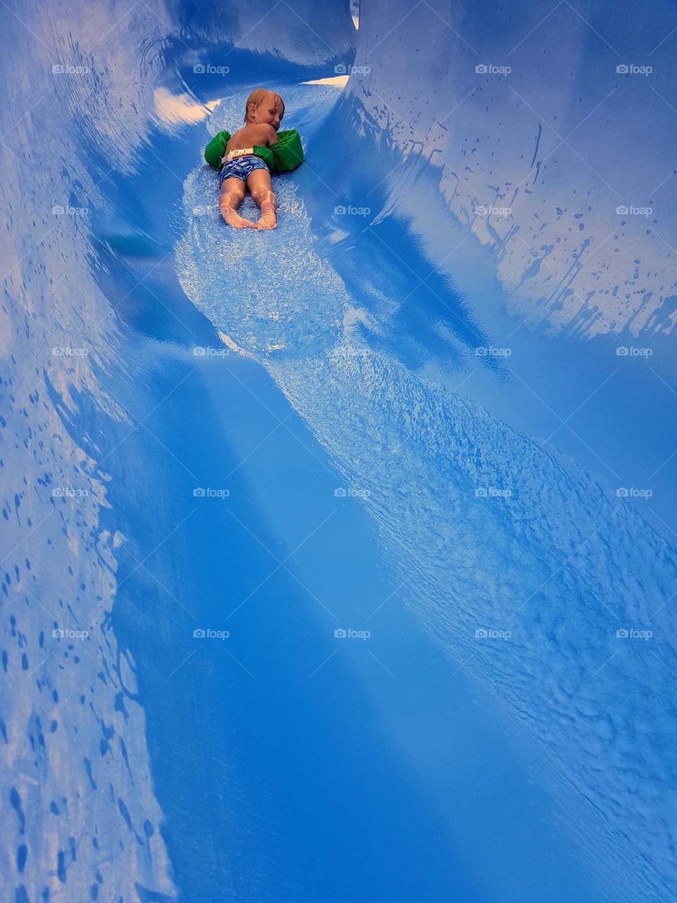little boy in water slide