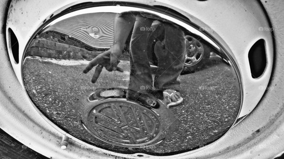 A reflective counterculture image of a 1972 Volkswagen beetle hubcab. Black and White