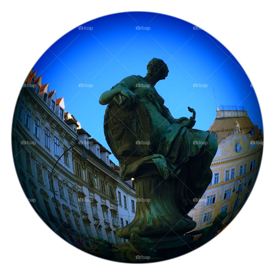 Beautiful street photography of statue in Vienna Austria ,flowing inside a round sphere by Lika Ramati art 