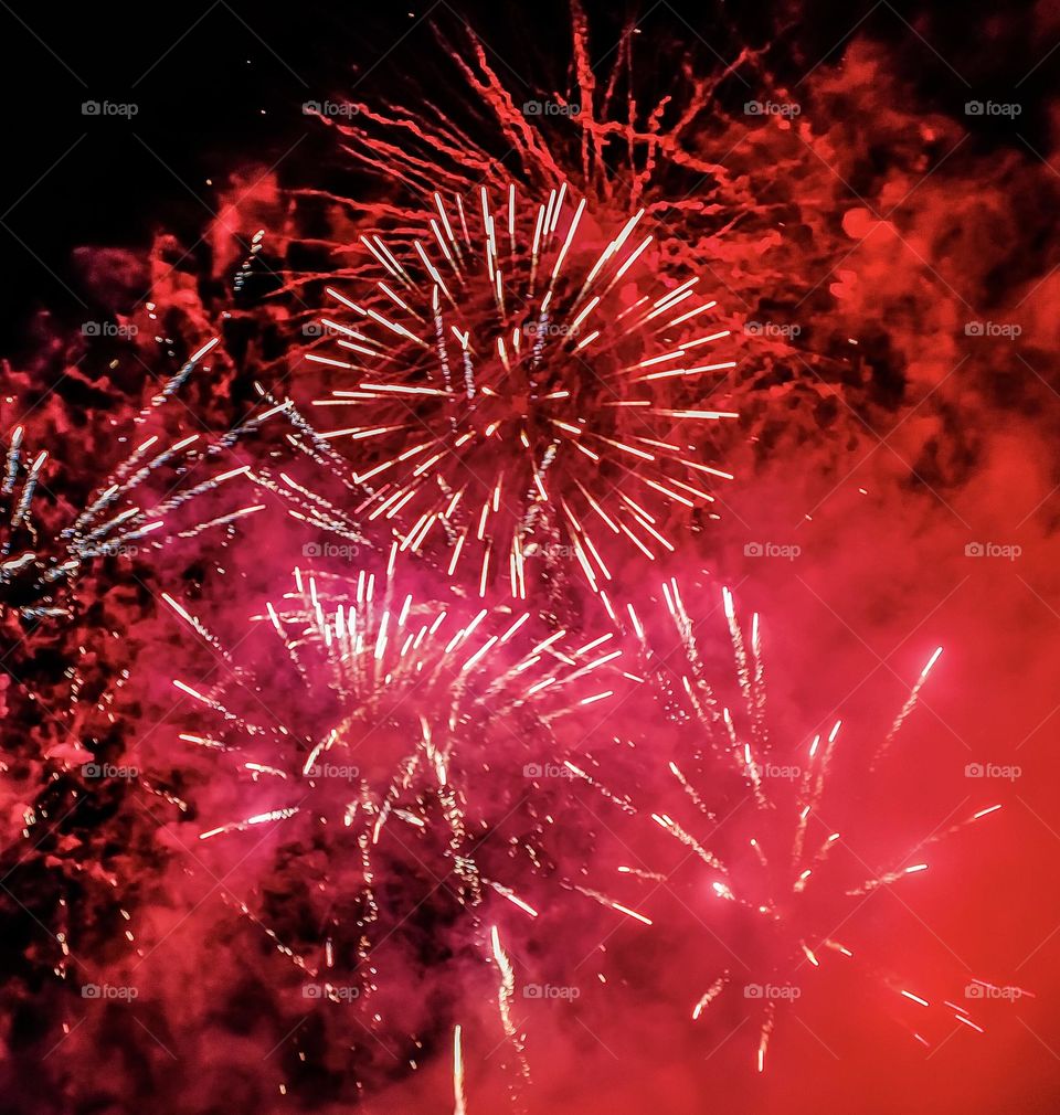 Red and pink fireworks and smoke on bonfire night