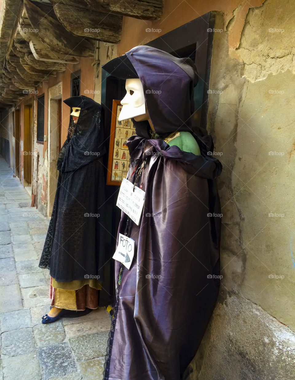 Dressed up puppets in front of a Venetian mask store. 