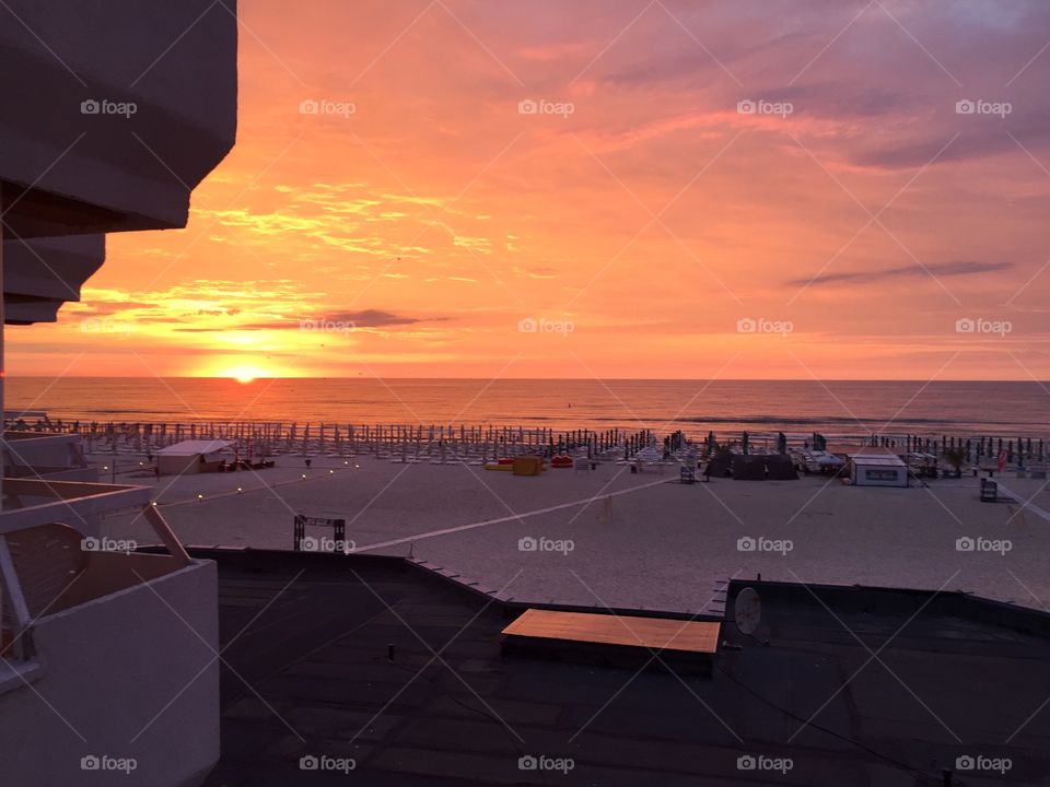 Bright orange sunrise at the sea seen from the hotel room