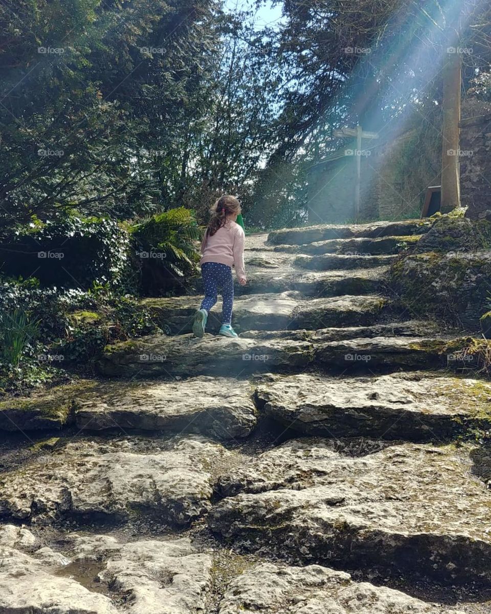 child running up garden steps in sunlight