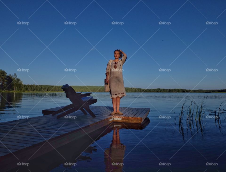 Young lady in a national dress. My daughter put Ukrainian national dress over and I took this picture while she was staying on a deck. Kivijarvi lake. 