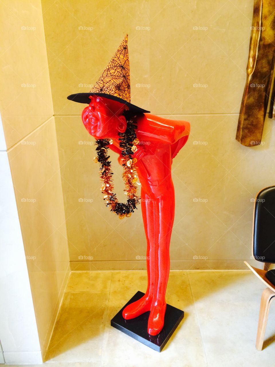Comedy sculpture Halloween . Funny sculpture in a lobby with Halloween hat and Hawaiian necklace 