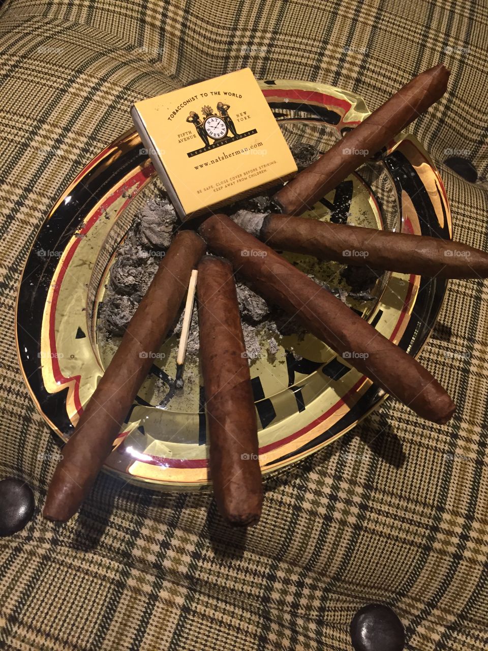 Five cigars in an ashtray 