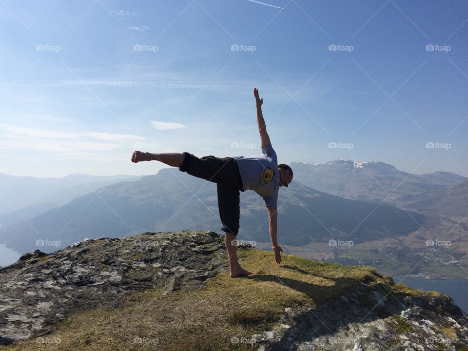 yoga in Scotland. Al doing half moon pose above Lochgoilhead in Scotland