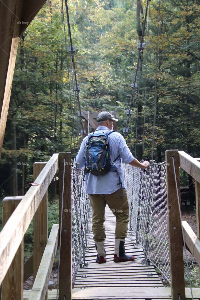 Man hiking across bridge in Ohio, USA