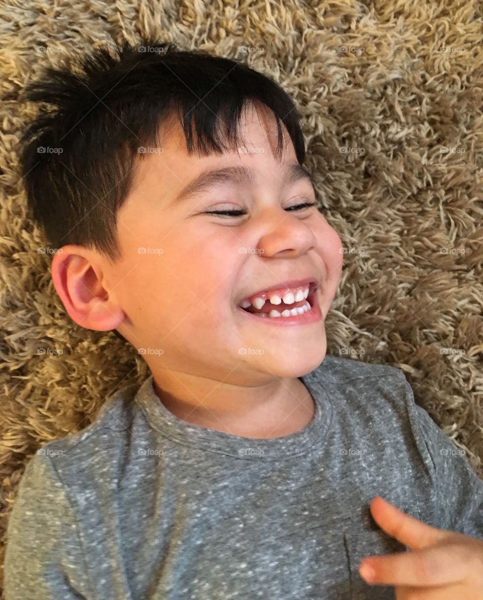 Boy lying on carpet