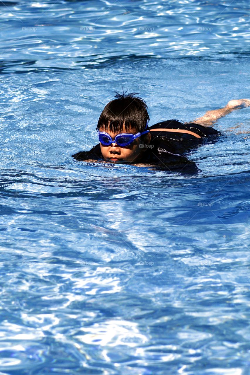 young kid swimming in a swimming pool