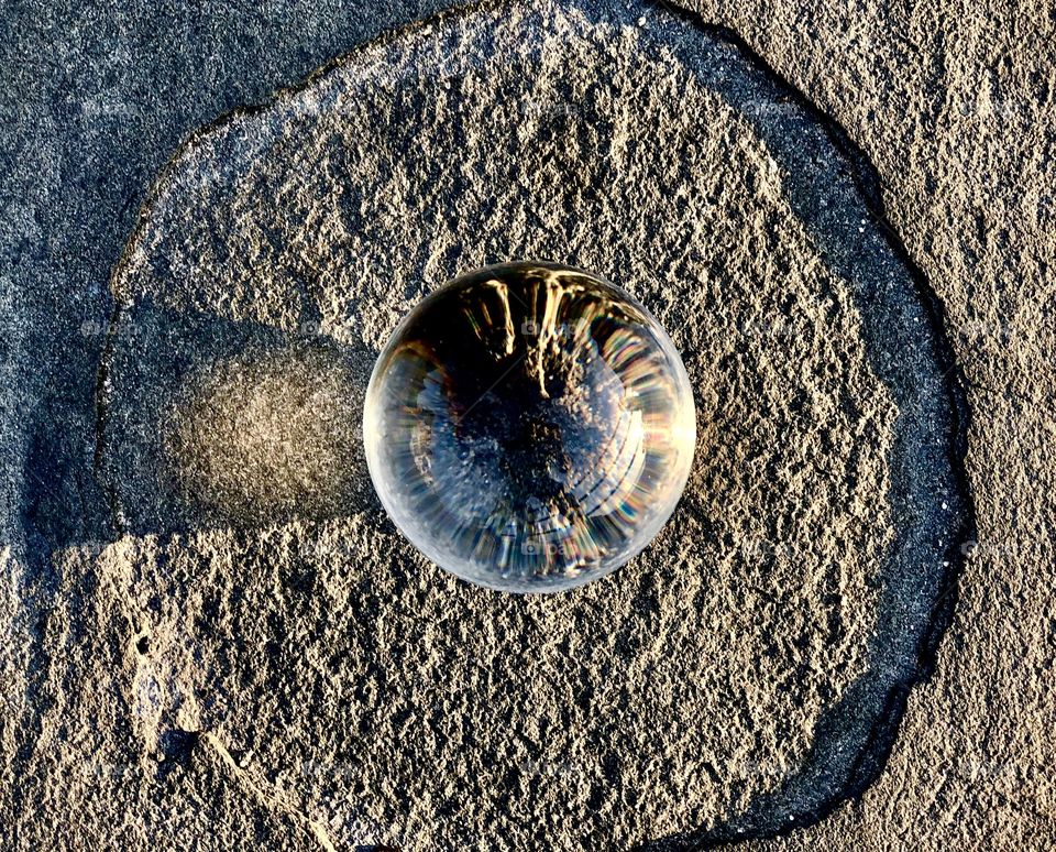 Glass ball inside circular base, grainy detail 