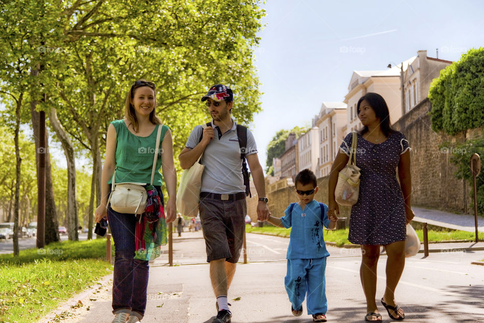 Family walk on a spring day. Enjoyable moment, quality time in family, walking in the city with all those trees and green