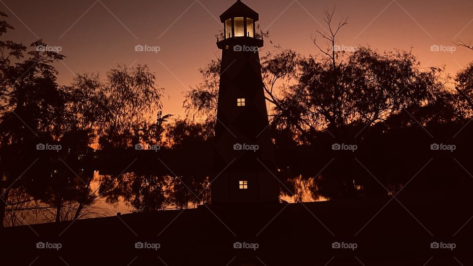 The Lighthouse is lit in the late evening Sunset. Twilight has taken over and soon will be night. 