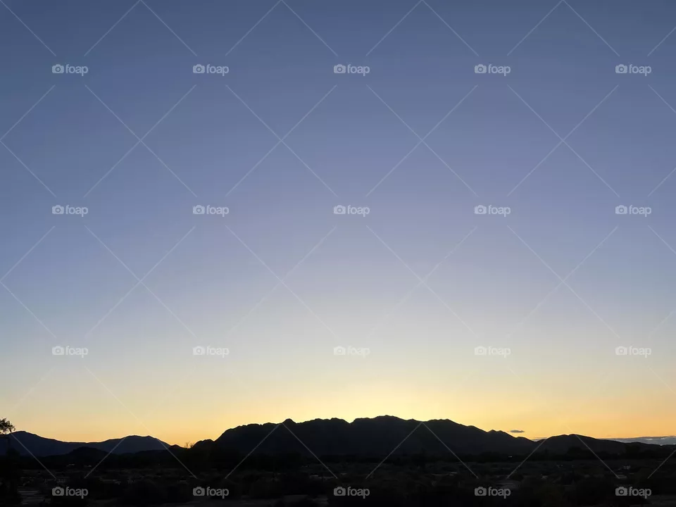 A colorful yellow sunset with mountains. 