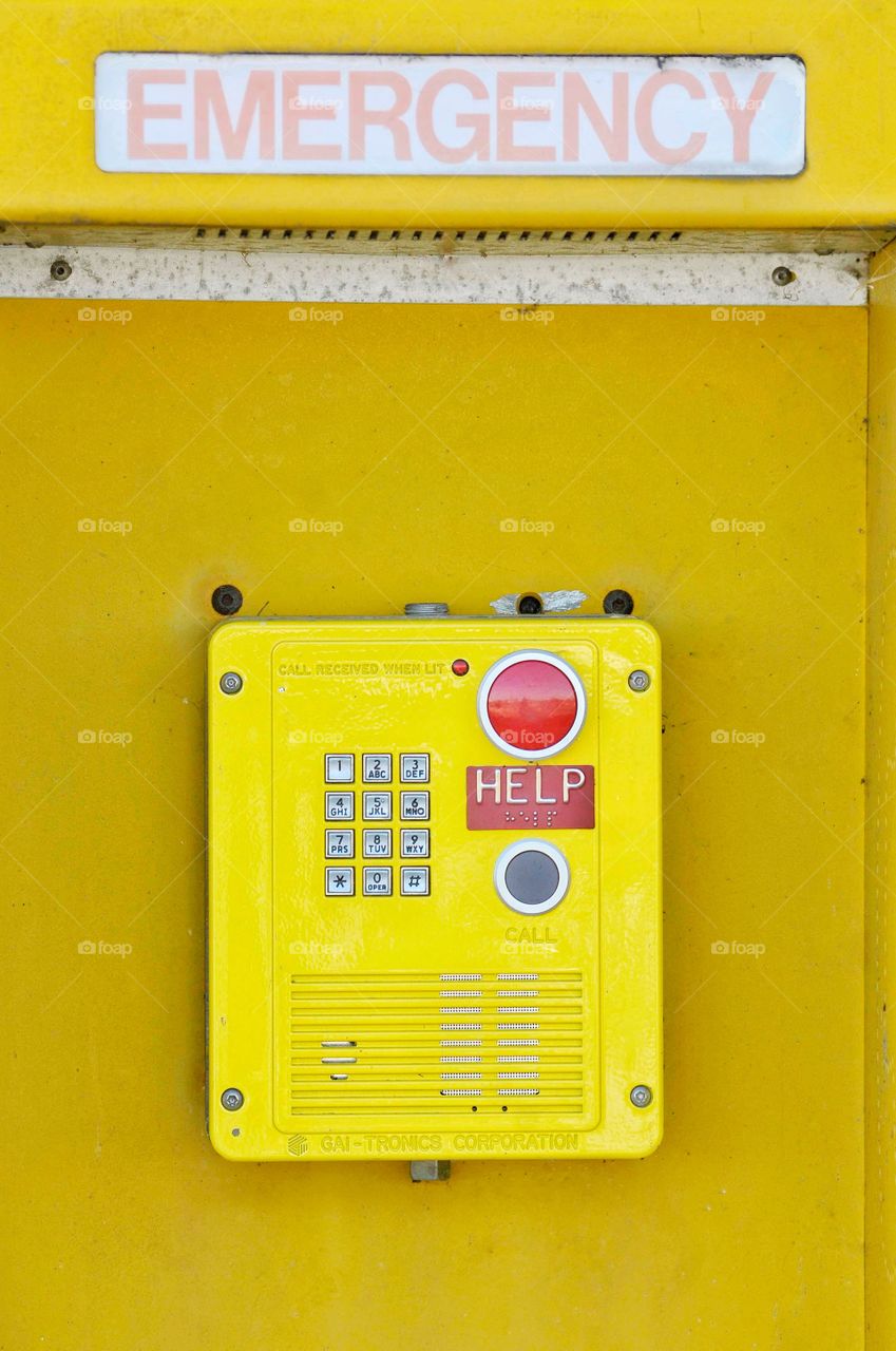 Yellow Emergency help box on a yellow board. 