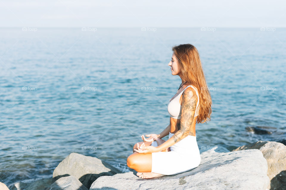 young fit beautiful woman with long hair in white sport clothes practice yoga and enjoy life on the sea beach, mental and phisical health