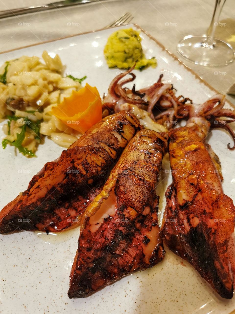 Delicious grilled calamari served on plate in restaurant