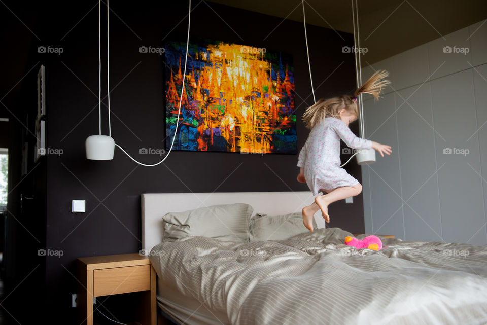 Girl jumping on bed