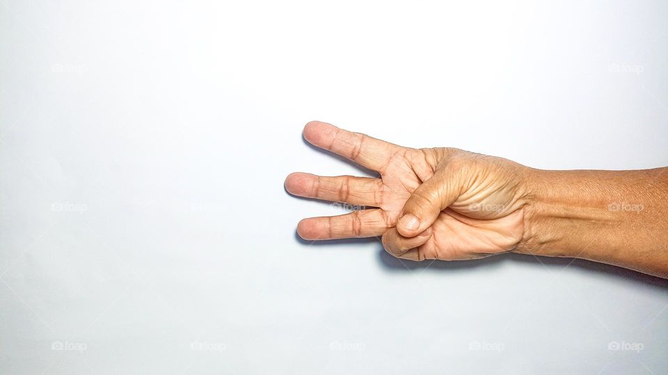 Hand is holding up three fingers in eye level view