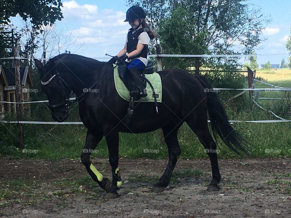 Girl riding big black horse