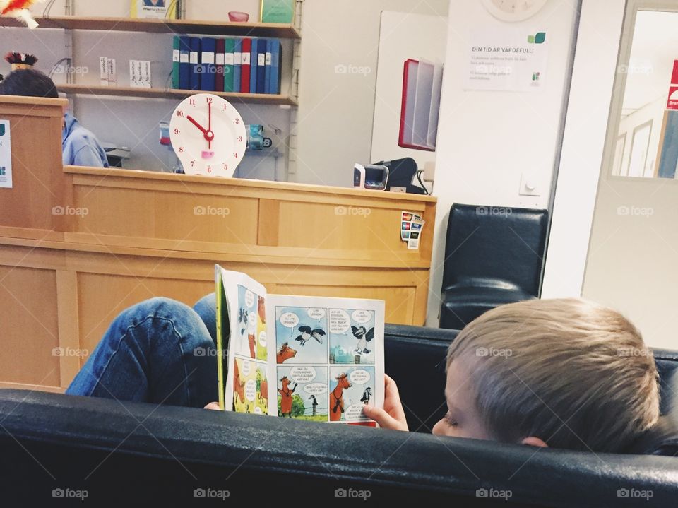 Boy reading in the waiting room