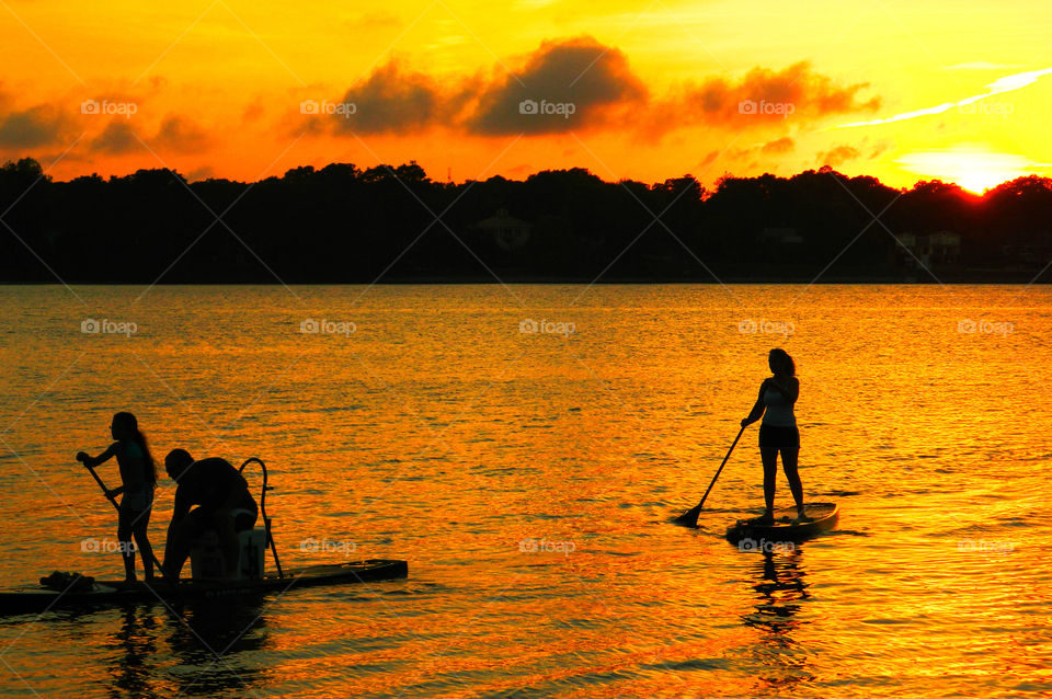 Paddle boarding family &Sunset. A family that plays together, stays together! This family is enjoying paddle boarding and the superb sunset evening!