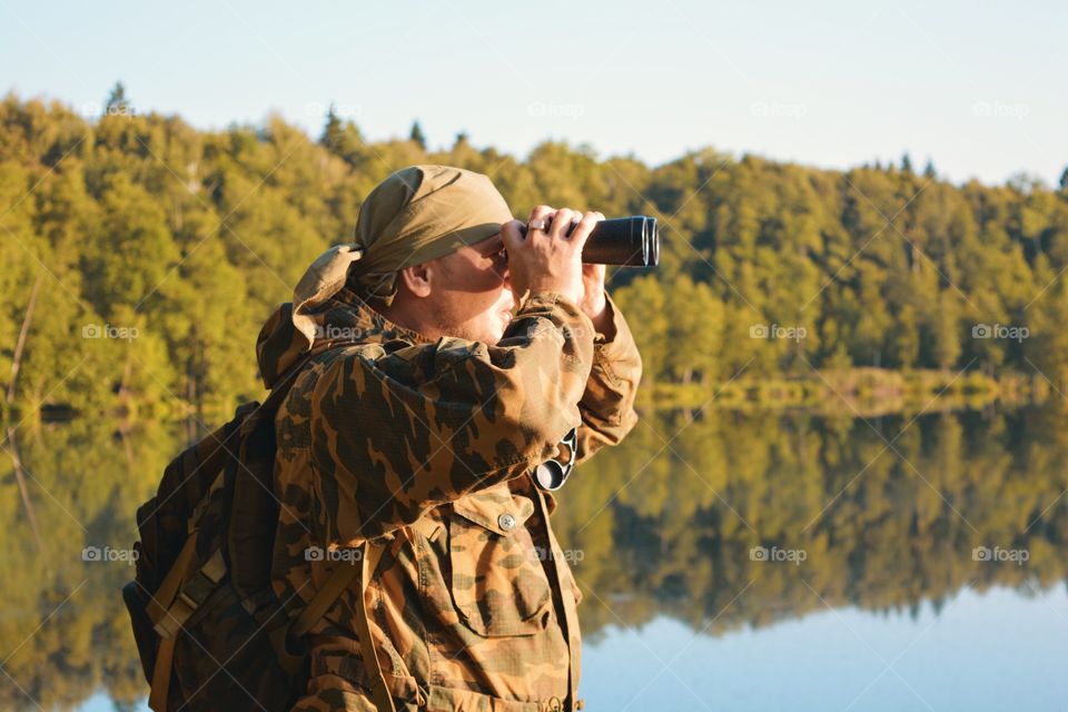 A man looks through binoculars