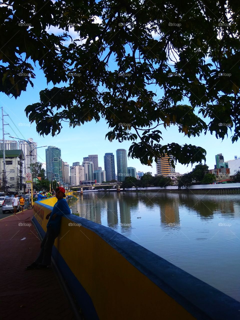 Local enjoying the view. It's a simple view in Metro Manila, Philippines. The tree added beauty to it. The Pasig river improved a lot through the effort of the government and the other concern citizens and we hope no one will throw waste here.
