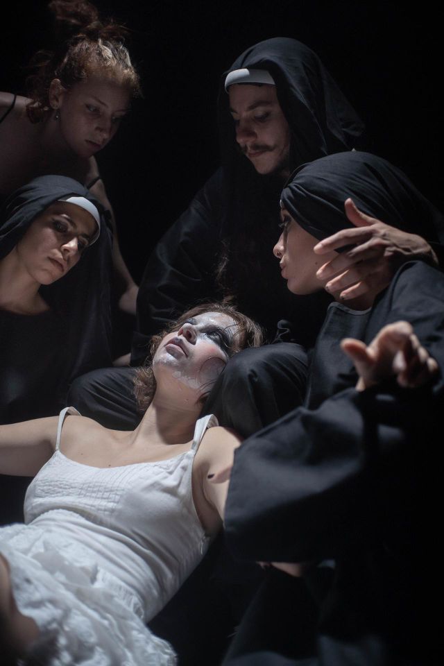 Group of nuns holding a woman in white