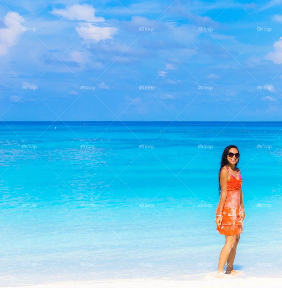 Woman in sunglasses standing at beach