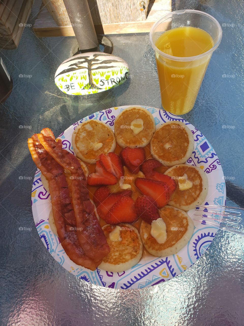 pancakes strawberries and bacon with a glass of oj