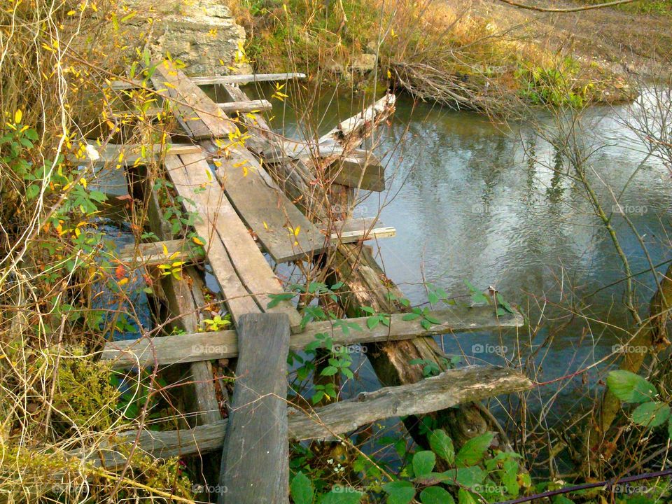Old demolished bridge on a small river