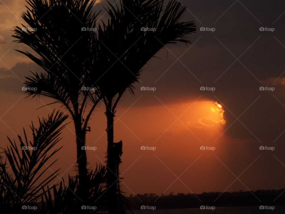 Por do sol. Nuvens escuras, sombra.