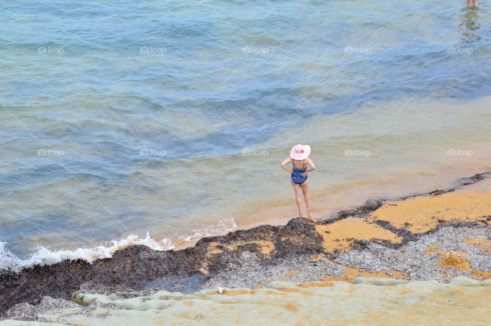 lady with hat on the seashore