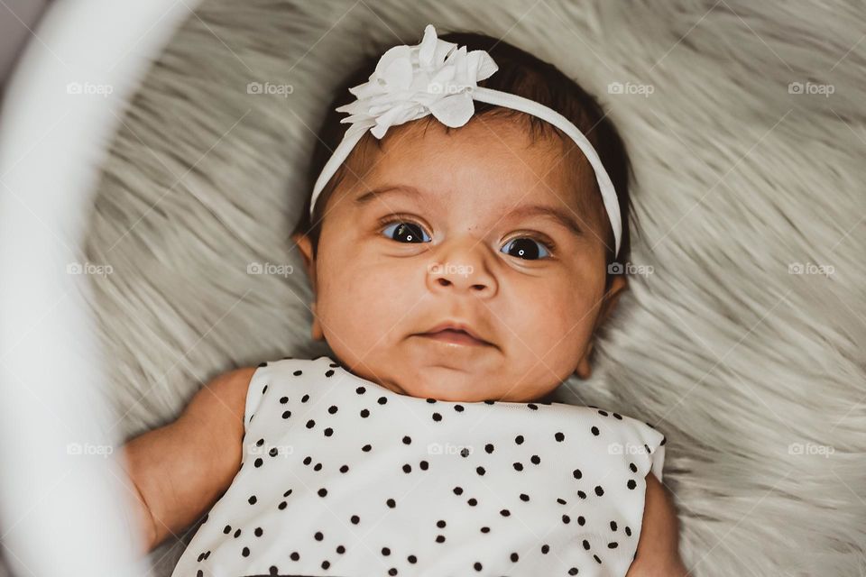 Baby surprised look on face, baby is surprised by ring light, baby girl with surprised look on her face, baby girl shows emotion of surprise 