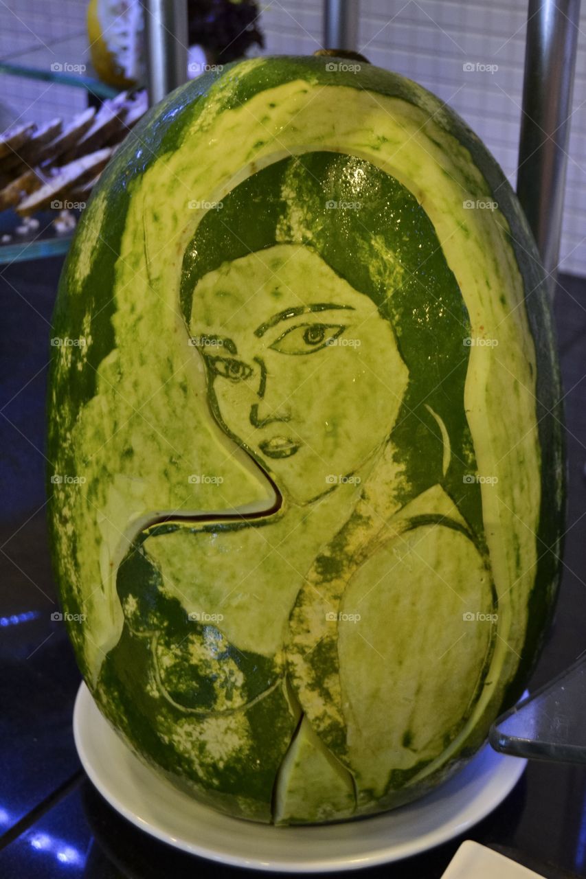 Decorative watermelon in the shape of a womans face.