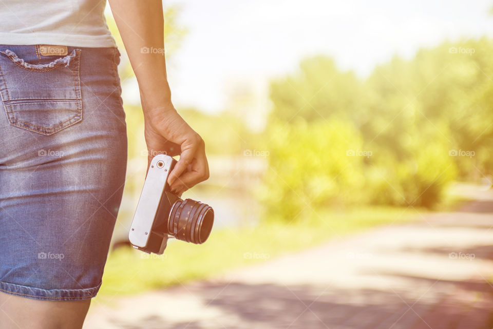 Woman hand holding retro camera. Young girl-photographer with film camera