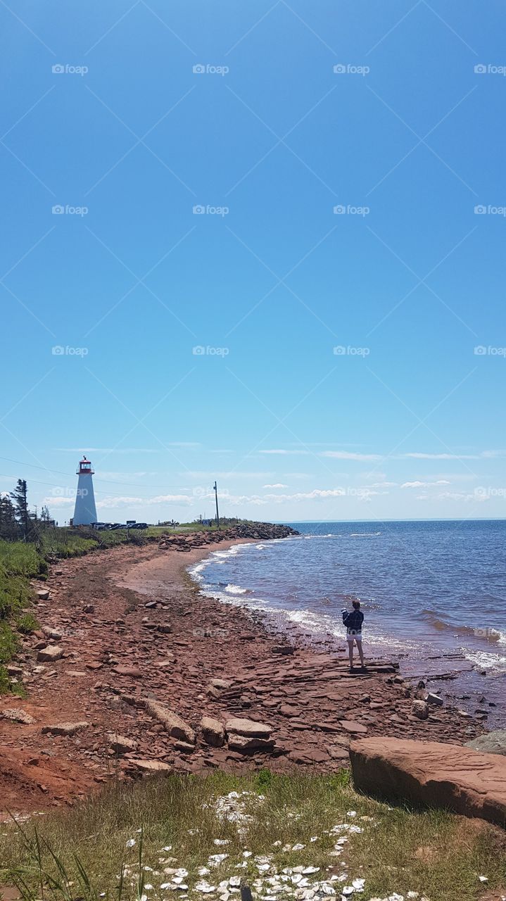 Point Prim with a woman and her child in  foreground, and the lighthouse and background