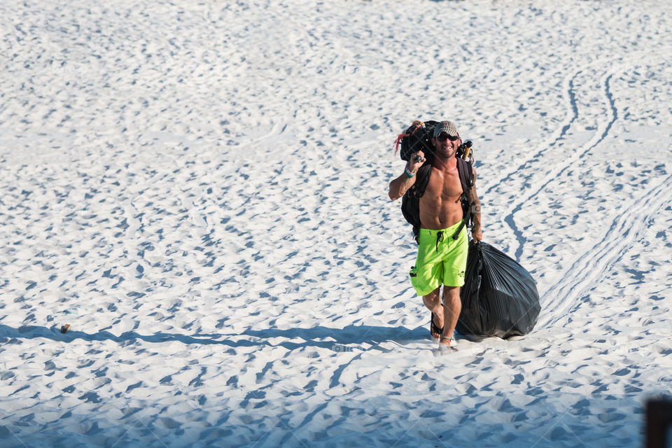 Backpacker walking on the beach with huge bag