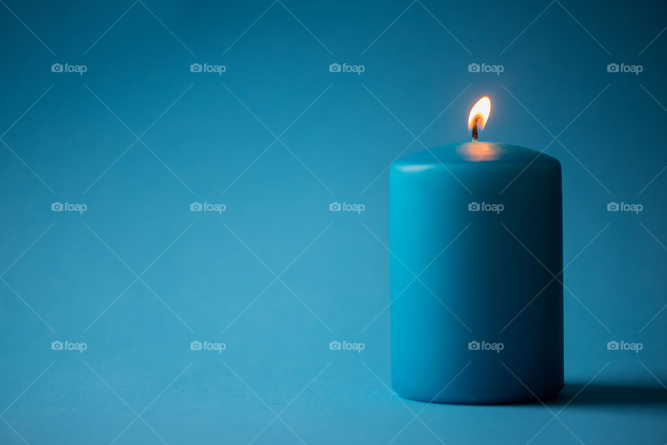 Blue candle on blue background